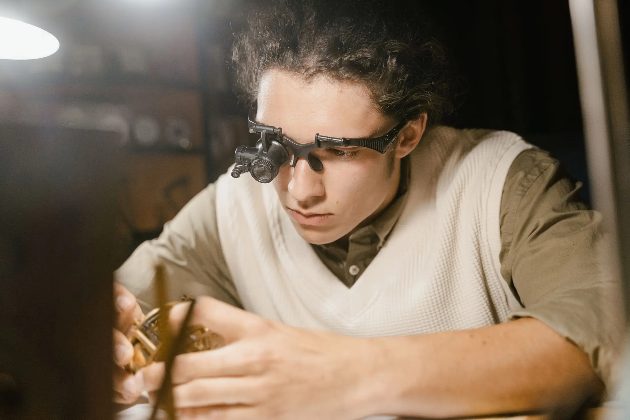 Horloger concentré à son établi, loupe sur les yeux